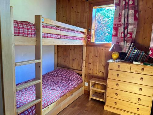 une chambre avec deux lits superposés et une commode dans l'établissement Appartement Spacieux - Terrasse, Jardin et Cheminée - À 5 Min du Centre des Gets - FR-1-623-100, aux Gets