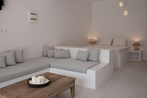 a white living room with couches and a wooden table at Thavma Boathouse in Firopótamos