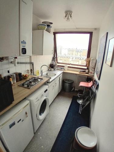une petite cuisine avec un évier et une machine à laver dans l'établissement jolie studio à paris 12 em, à Paris