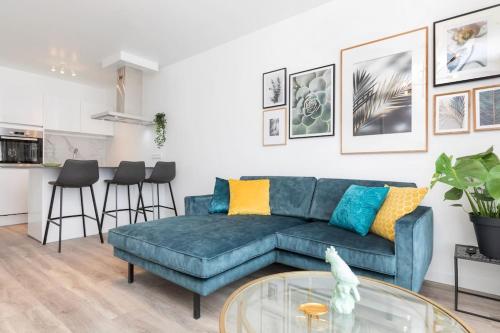 a living room with a blue couch and a glass table at Eindhoven City Suites Hoogstraat D Modern 2P in Eindhoven