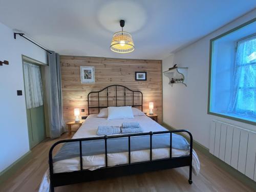 - une chambre avec un lit et un mur en bois dans l'établissement La Chaumière, à Saulxures-sur-Moselotte