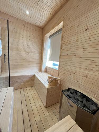 un sauna en bois avec une baignoire et une fenêtre dans l'établissement La Chaumière, à Saulxures-sur-Moselotte