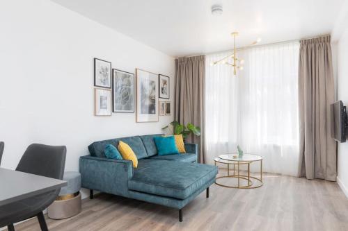 a living room with a blue couch and a table at Eindhoven City Suites Hoogstraat D Modern 2P in Eindhoven