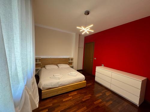 a bedroom with a bed and a red wall at Vittoria apartment - near outlet in Noventa di Piave