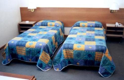 dwa łóżka siedzące obok siebie w pokoju w obiekcie Hotel Capri w mieście Pasian di Prato