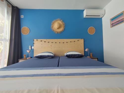 a blue bedroom with a bed with a blue wall at Eskal Péi - Auberge de Jeunesse & Chambres d'hôtes in Étang-Salé