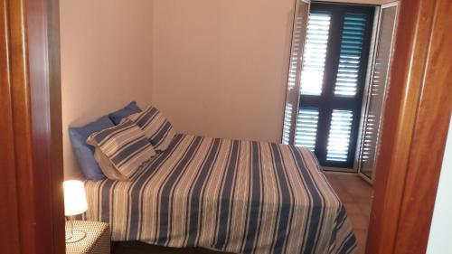 a small bedroom with a bed and a window at Ionio in Reggio Calabria