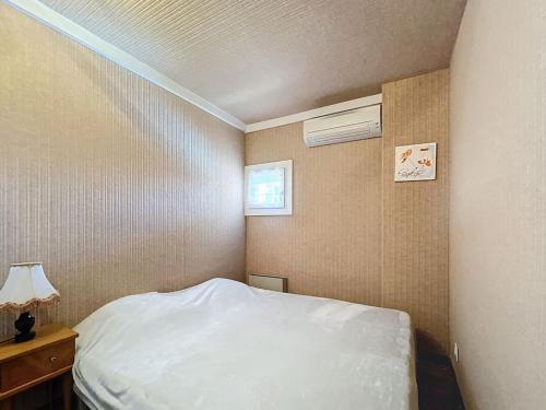 une petite chambre avec un lit et une fenêtre dans l'établissement 3384-Appartement 2 pièces résidence avec piscine, à Argelès-sur-Mer