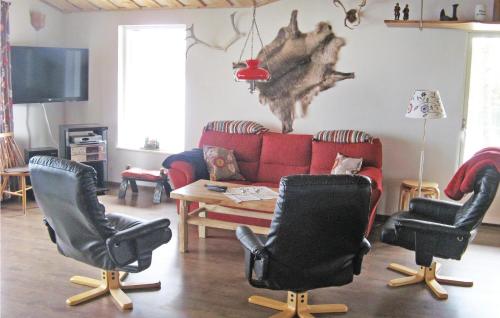 a living room with a red couch and two chairs at Lovely Home In Skånes Fagerhult in Skånes Värsjö