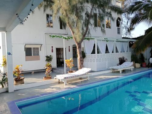 a hotel with a swimming pool and a building at Nyumba Tulivu in Watamu