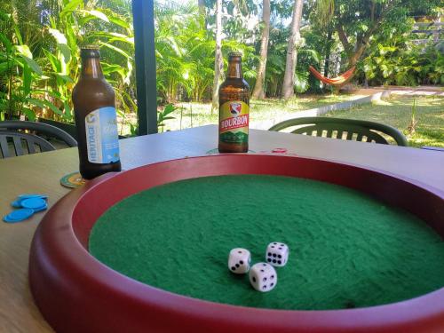 a table with two bottles of beer and dice at Eskal Péi - Auberge de Jeunesse & Chambres d'hôtes in Étang-Salé