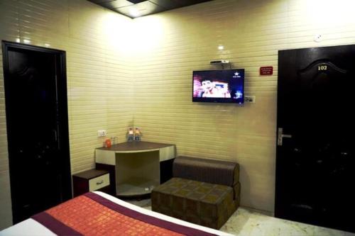 a bedroom with a table and a tv on the wall at HOTEL HOLY CITY in Amritsar
