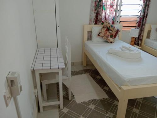 a small room with a bed and a table at Nyumba Tulivu in Watamu