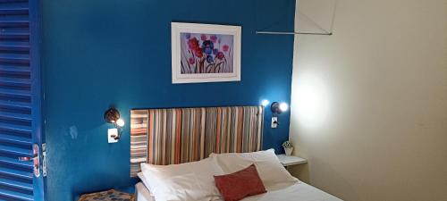 a bedroom with a blue wall and a bed at Pousada Canto dos Passaros in Chapada dos Guimarães