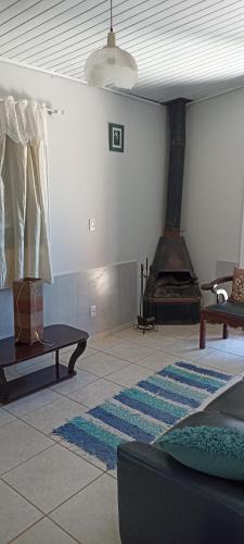 a living room with a fireplace and a rug at Pousada Canto dos Passaros in Chapada dos Guimarães