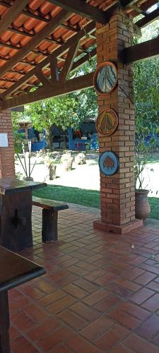 a clock tower in a patio with a picnic table at Pousada Canto dos Passaros in Chapada dos Guimarães