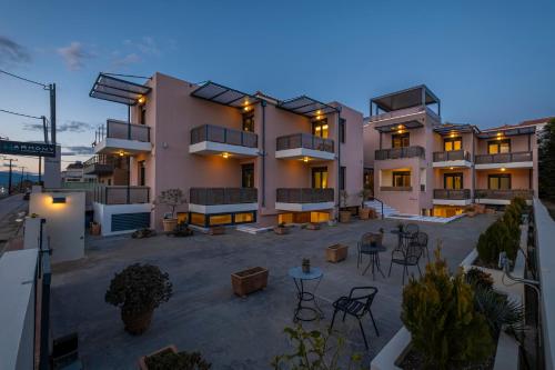 a large building with tables and chairs in a courtyard at Harmony Hotel Nafplio in Nafplio