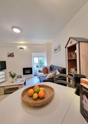 un salon avec un bol de fruits sur une table dans l'établissement LE MISTRAL DU CENTRE VILLE ,chaleureux à 2 min de la plage, à Dinard