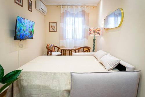une chambre avec un lit blanc et une table dans l'établissement Encantador apartamento céntrico en Barrio Salamanca, junto a WiZink Center Movistar Arena y Plaza de Toros Las Ventas, à Madrid