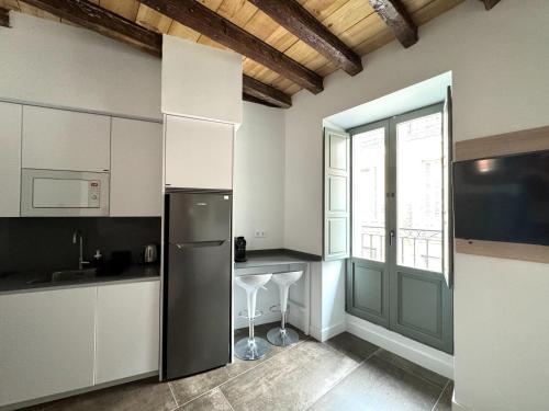 a kitchen with a stainless steel refrigerator and a window at CavaBajaSuites in Madrid