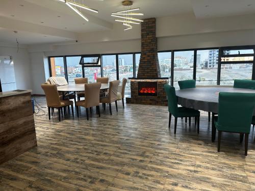 DalandzadgadKhovuun hotel的一间有桌椅和壁炉的餐厅