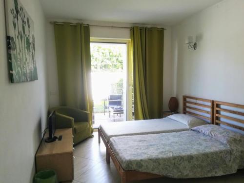 una camera da letto con un letto, una tv e una finestra di Alloggio Turistico Castel di Leva a Castel di Leva