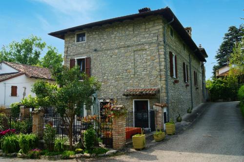 a stone house with a fence in front of it at Dulcius ex Asperis Bed & breakfast in Ponte Nizza