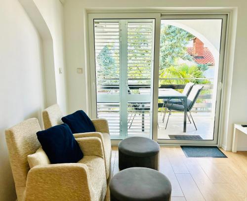 a living room with two chairs and a table with a patio at Apartments Bella Vita 1 in Malinska