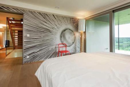 a bedroom with a white bed and a red chair at luxe vakantiehuis met panoramisch uitzicht Nisramont in La Roche-en-Ardenne