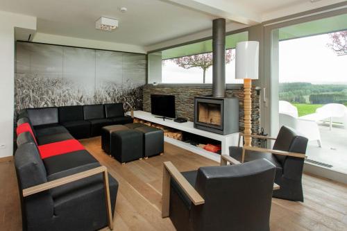 a living room with a couch and a fireplace at luxe vakantiehuis met panoramisch uitzicht Nisramont in La Roche-en-Ardenne