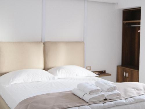 a bed with white towels sitting on top of it at Villa Tragos in Vlorë