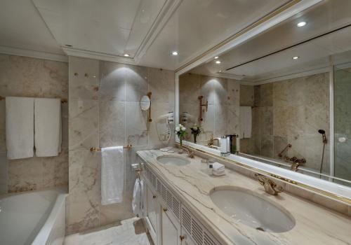 a bathroom with two sinks and a large mirror at Maritim Airport Hotel Hannover in Hannover