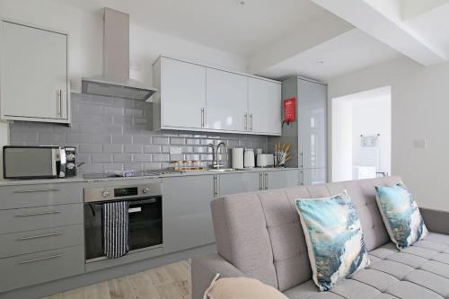 a living room with a couch and a kitchen at Modern 2 Bed Apartment with Patio Central Leicester in Leicester