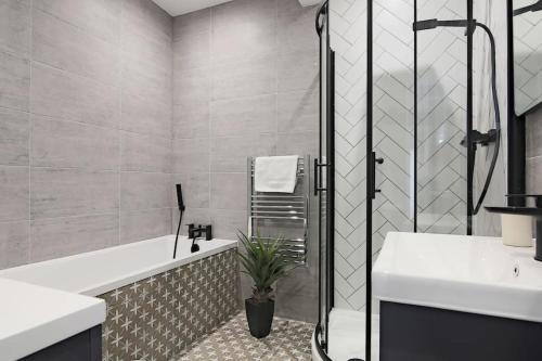 a bathroom with a tub and a sink and a shower at Modern 2 Bed Apartment with Patio Central Leicester in Leicester