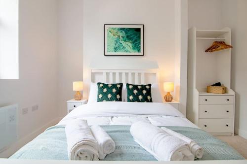 a white bedroom with a bed with towels on it at Modern 2 Bed Apartment with Patio Central Leicester in Leicester