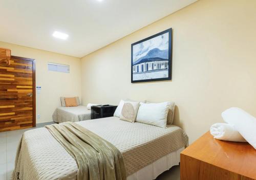 a small bedroom with two beds and a table at Hotel Santa Maria in Pirenópolis