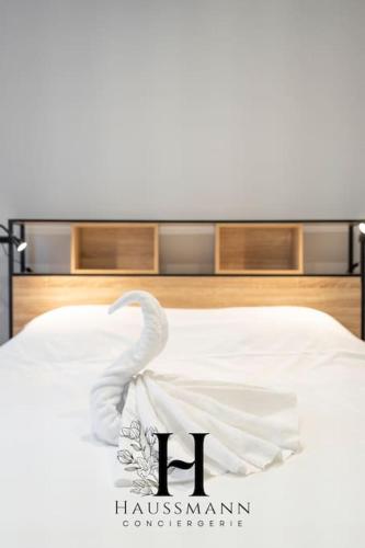 Cette chambre comprend un lit blanc et une serviette. dans l'établissement Magnifique Appartement Pop Art Nancy, à Nancy