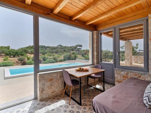 a bedroom with a bed and a table and windows at Vine House in Isterni