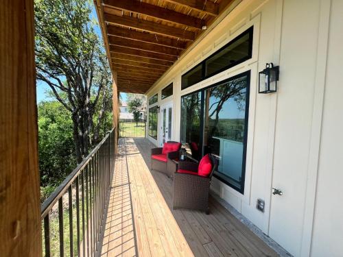 a screened porch with red chairs on a house at The Riverscape at Gruene in New Braunfels
