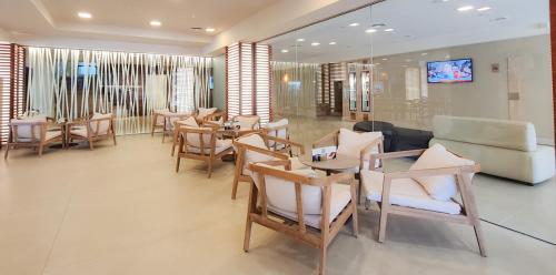 a living room with chairs and tables and a couch at Hotel Cesar Augustus in Cambrils