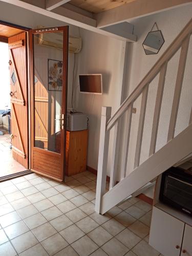 Cette chambre est dotée d'un escalier avec une porte et une télévision. dans l'établissement Maison 4 à 6 personnes climatisée, à Port-Leucate