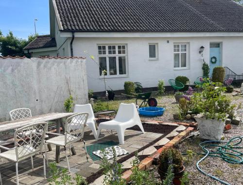 a backyard with a table and chairs and a house at St'ngt in Borrby