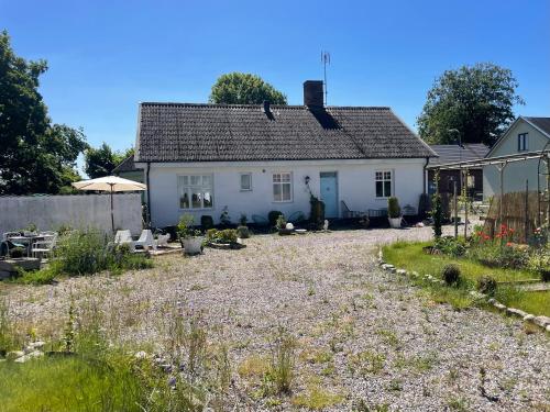 a white house with a garden in front of it at St'ngt in Borrby