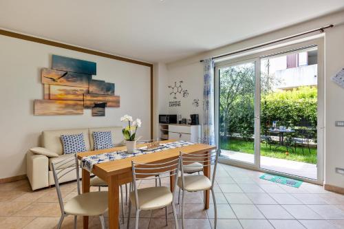 a dining room with a table and chairs and a window at Bluemoon -luminoso apt con piscina in Lazise