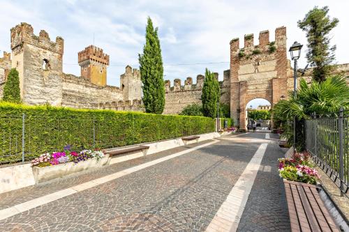 a street in front of a building with a gate at Bluemoon -luminoso apt con piscina in Lazise