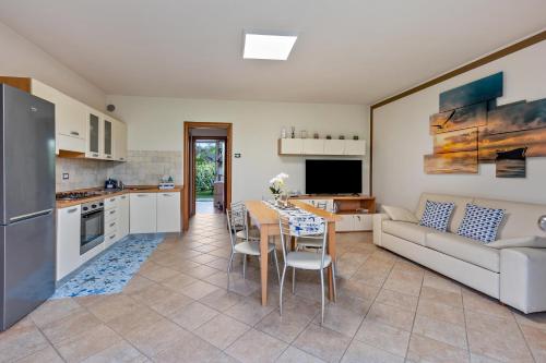 a kitchen and living room with a table and a couch at Bluemoon -luminoso apt con piscina in Lazise