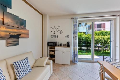 a living room with a couch and a table at Bluemoon -luminoso apt con piscina in Lazise