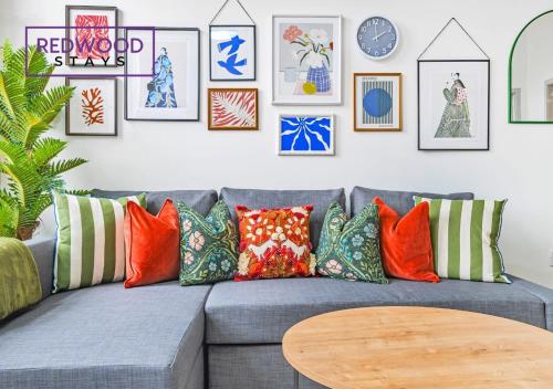 a living room with a gray couch with colorful pillows at Comfortable and Homely 1-Bedroom 1-Bathroom Serviced Apartment with Free Parking, Free WiFi By Redwood Stays in Farnborough