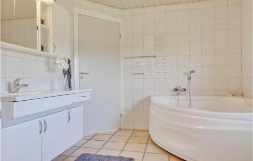 ein weißes Badezimmer mit Badewanne und Waschbecken in der Unterkunft Holiday Home Hvedemarken Sjølund I in Hejls