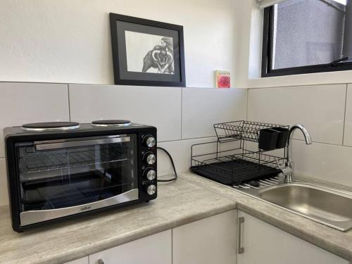 a microwave sitting on a kitchen counter next to a sink at 31Ridge Road in Durbanville